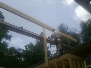 Carpenter setting a ridge beam over a new addition frame — Ice Dam Removal by Roofing Brothers in Higginsville