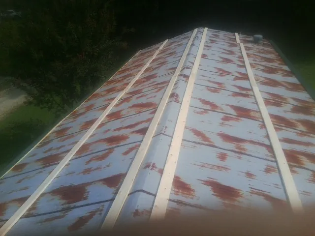 Rusted metal roof panels with new wood purlins before replacement — Storm Damage Roof Repair in Higginsville by Roofing Brothers