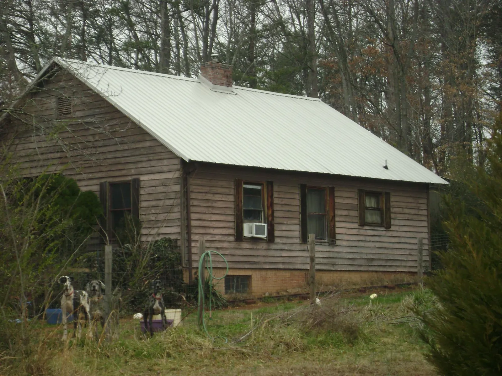 White metal roof on an old wood sided farmhouse, from a Metal Roof Installation job in Higginsville